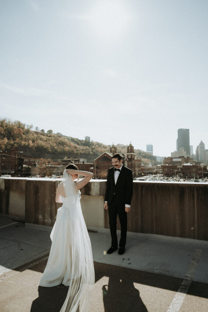 first look between bride and groom with pittsburgh skyline behind them